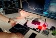 Persona al lavoro con doppio monitor, rappresenta l'adozione di Claude AI nel settore finanziario tramite TCS e DXC