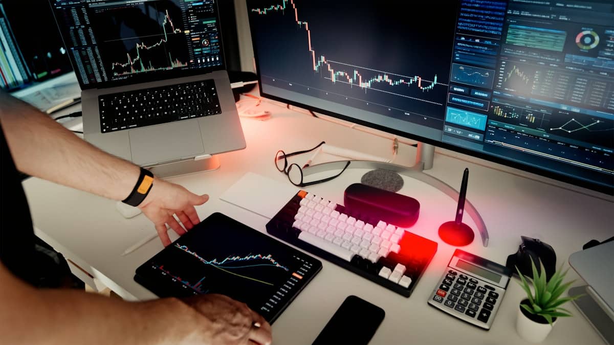 Persona al lavoro con doppio monitor, rappresenta l'adozione di Claude AI nel settore finanziario tramite TCS e DXC