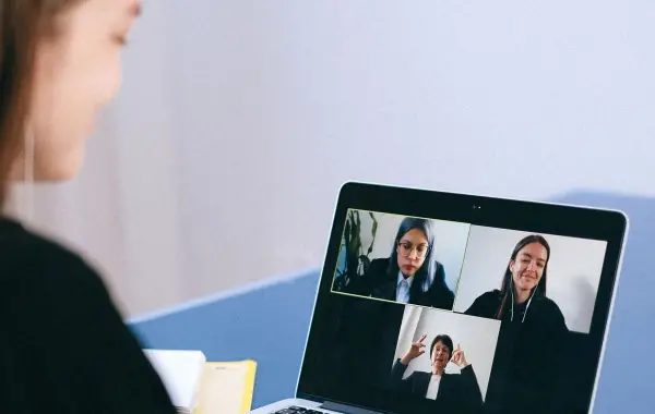 Persone che partecipano a una videochiamata di lavoro su un computer portatile