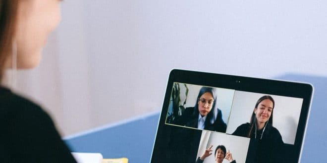 Persone che partecipano a una videochiamata di lavoro su un computer portatile