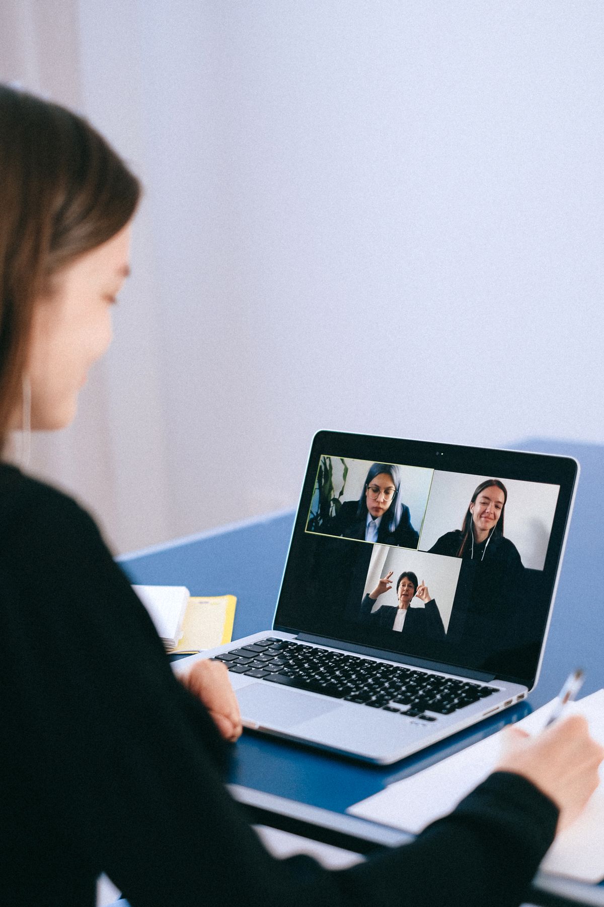 Persone che partecipano a una videochiamata di lavoro su un computer portatile