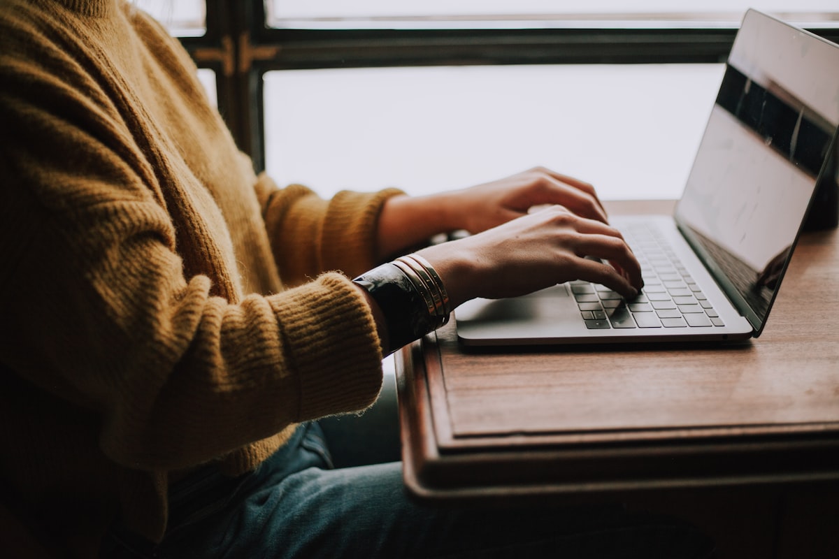 Persona seduta davanti al computer portatile mentre studia