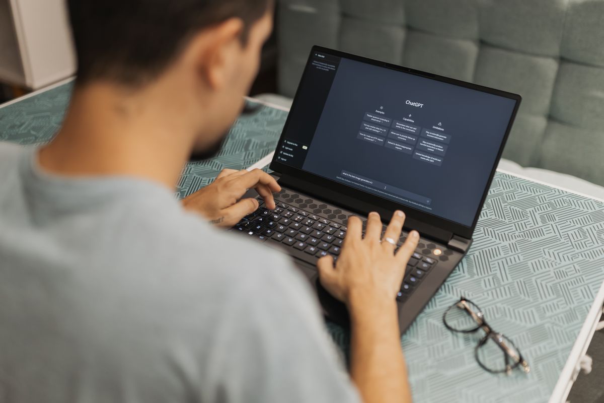 Persona che usa un assistente di intelligenza artificiale su un computer portatile