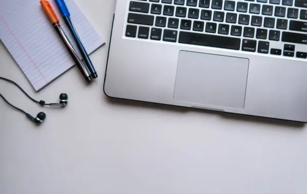 Laptop e blocco appunti su una scrivania per lo studio, a rappresentare l'uso di ChatGPT da parte degli studenti