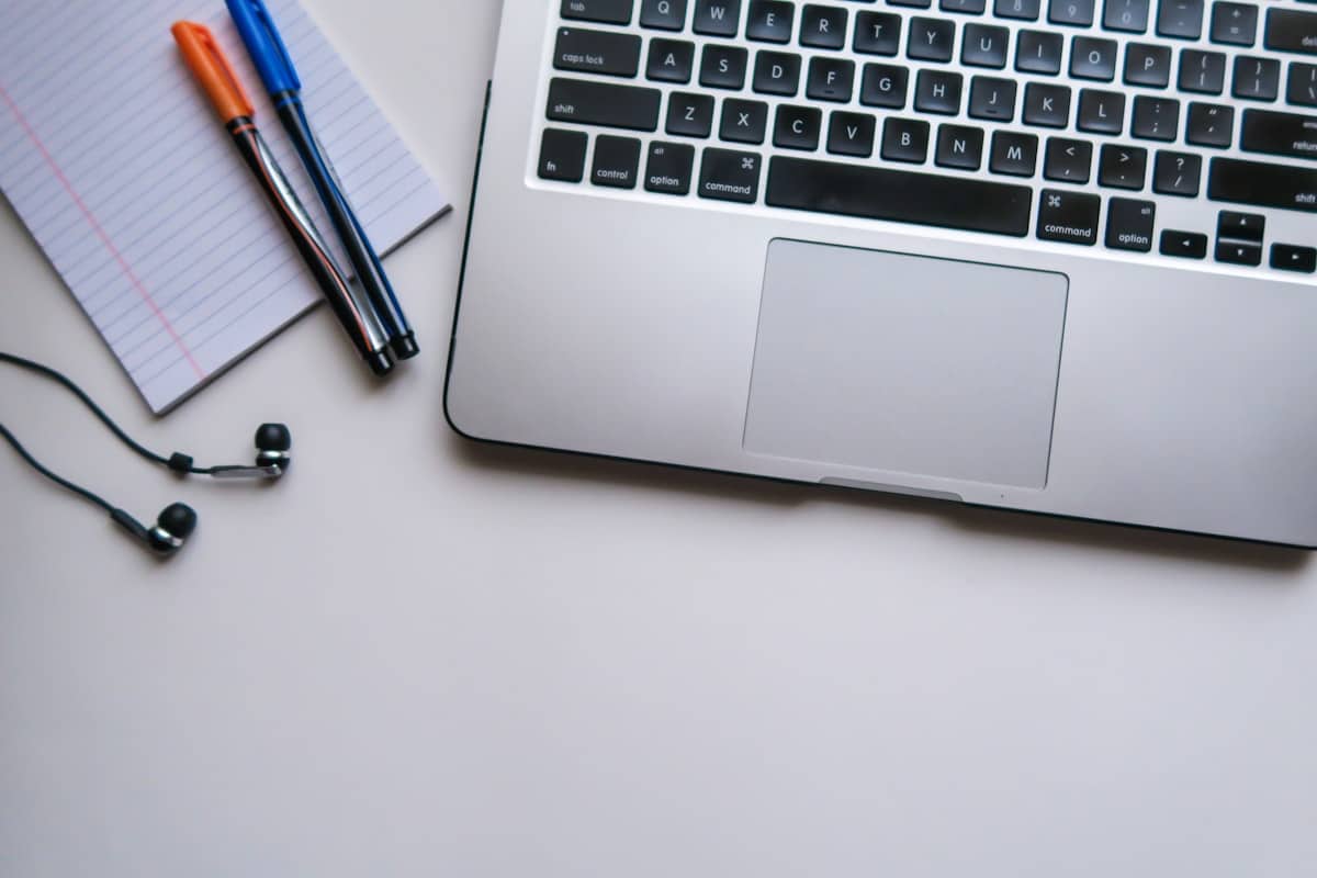Laptop e blocco appunti su una scrivania per lo studio, a rappresentare l'uso di ChatGPT da parte degli studenti