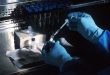 Ricercatore in laboratorio con struttura del DNA, ricerca scientifica accelerata dall intelligenza artificiale