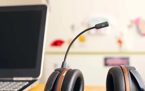 Auricolare accanto a un computer portatile, immagine simbolica degli agenti AI vocali e di chat di OpenAI Presence