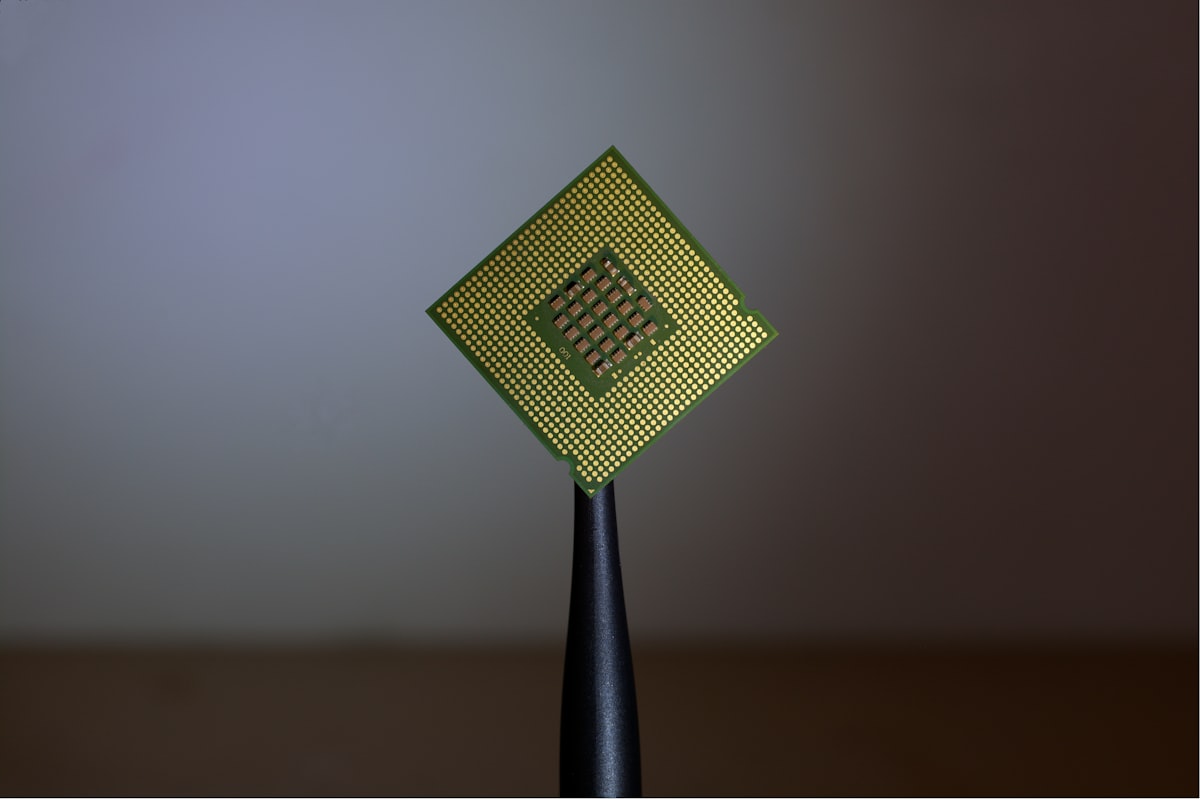 Processore per computer tenuto con pinzette, simbolo della progettazione di chip AI su misura