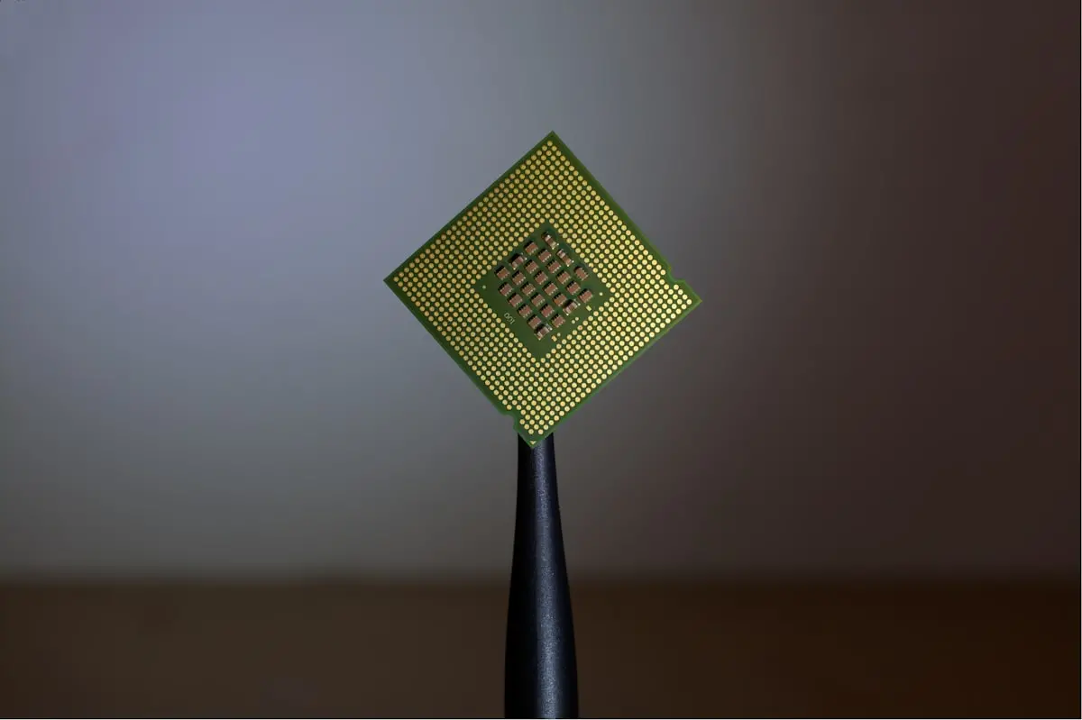 Processore per computer tenuto con pinzette, simbolo della progettazione di chip AI su misura
