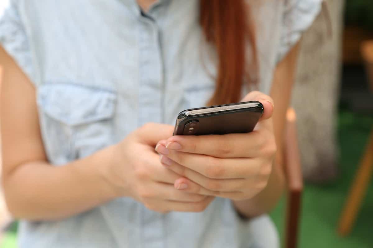 Mano che tiene uno smartphone, immagine simbolica del lancio di ChatGPT for Teens di OpenAI