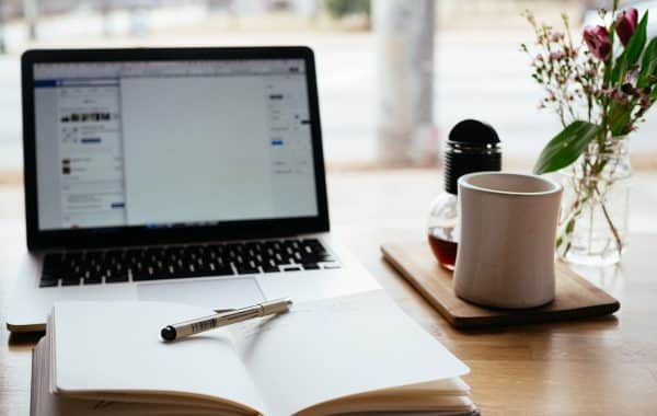 Computer portatile aperto accanto a un libro, simbolo della formazione online sull intelligenza artificiale