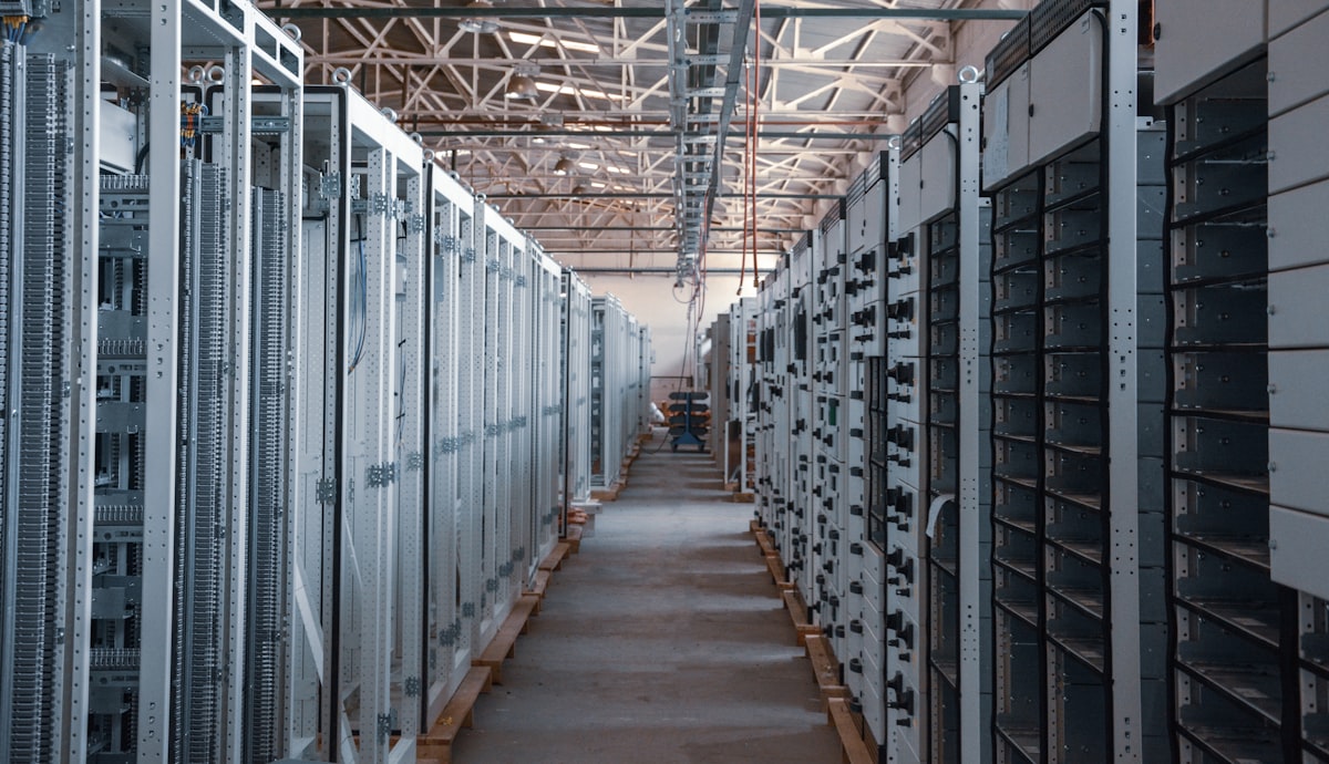 Corridoio di un data center con rack di server, l'infrastruttura di calcolo necessaria per addestrare grandi modelli di intelligenza artificiale