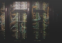 Corridoio di un data center con rack di server, simbolo del consumo energetico dell'intelligenza artificiale