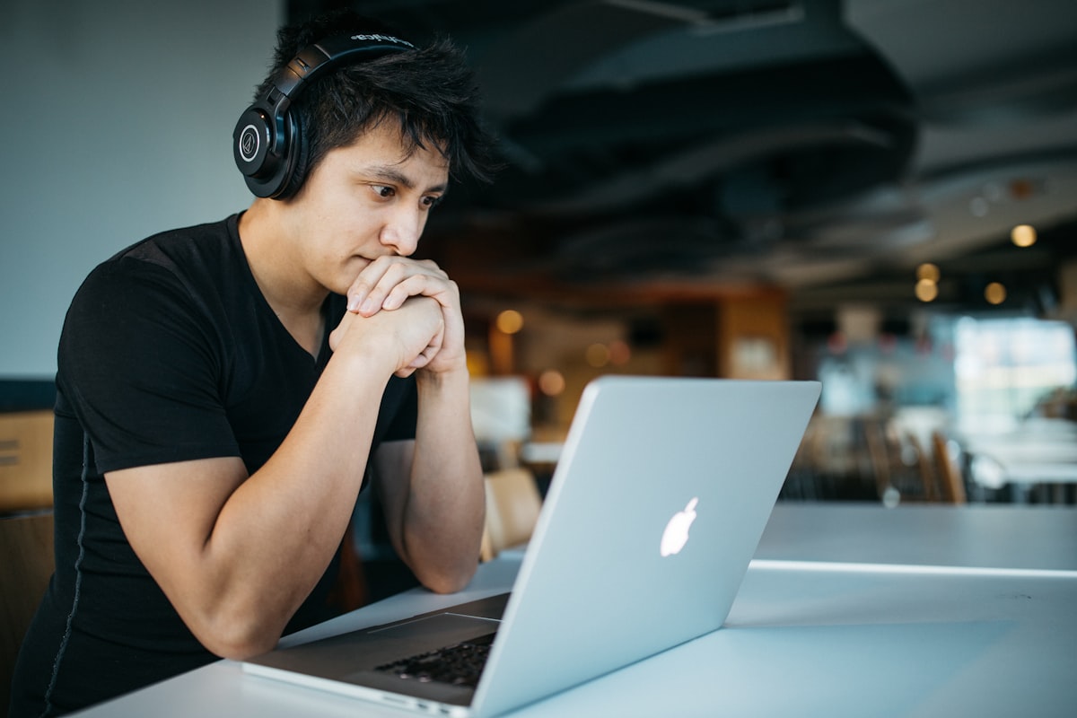 Studente che studia al computer portatile con quaderno e appunti
