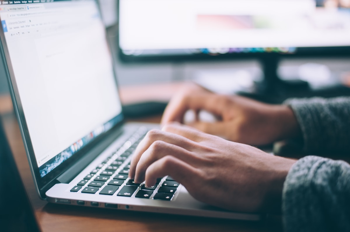Persona che scrive al laptop usando generatori di testo AI