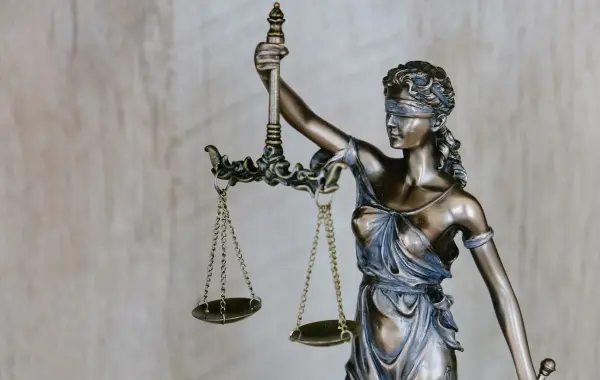Statua della giustizia con la bilancia, simbolo dell indagine legale su OpenAI e Sam Altman