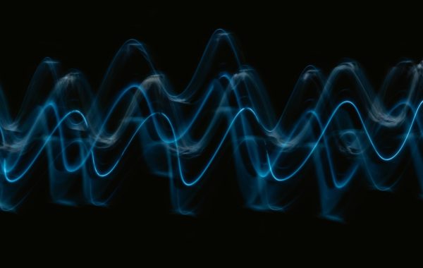 Onda sonora blu astratta su sfondo nero, simbolo della voce generata dall'intelligenza artificiale