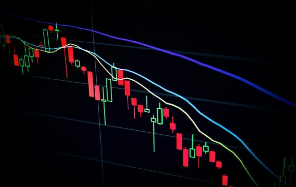 Grafico a candele del mercato azionario su schermo scuro, a rappresentare la trimestrale di Palantir e la crescita della domanda di AI