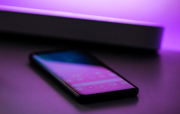 Smartphone Android appoggiato su una scrivania con luce viola, simbolo del passaggio da Google Assistant a Gemini