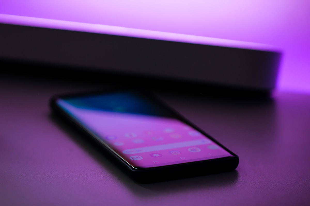 Smartphone Android appoggiato su una scrivania con luce viola, simbolo del passaggio da Google Assistant a Gemini