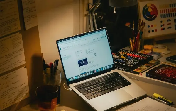 Scrivania con portatile, libri e appunti per studiare con l'intelligenza artificiale