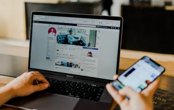 Persona che usa laptop e smartphone, immagine simbolica della pubblicità di Amazon dentro ChatGPT