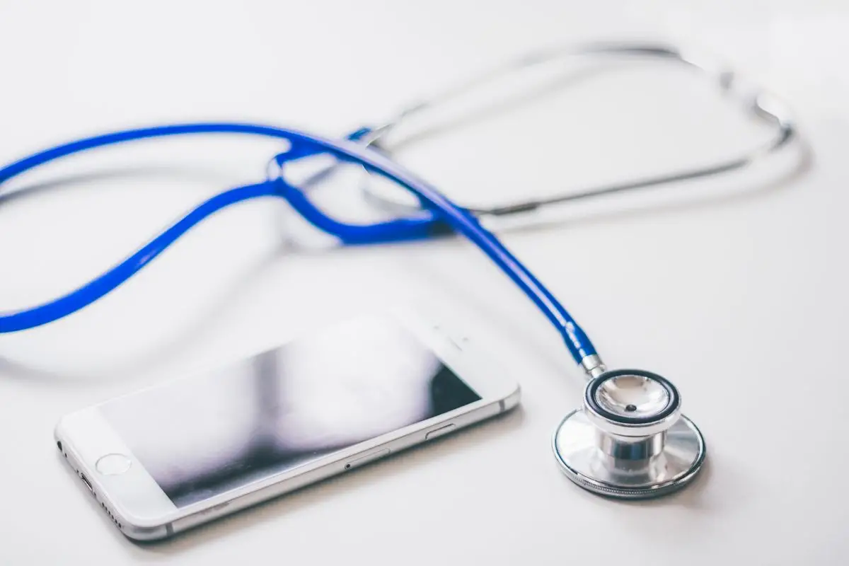 Stetoscopio e smartphone su una superficie bianca, simbolo dell'AI clinica accessibile ai medici