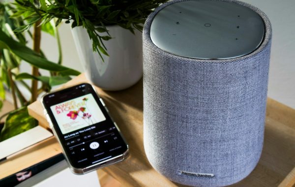 Smartphone collegato a uno smart speaker, simbolo di assistente vocale con app collegate