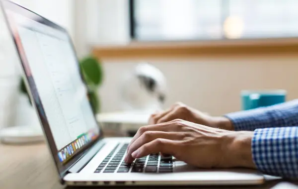 Persona che scrive al computer portatile, immagine simbolica della funzione Writing Style di ChatGPT