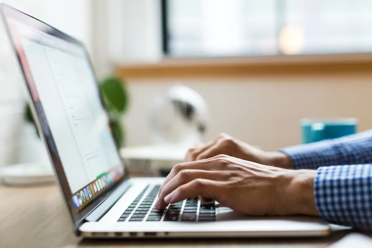 Persona che scrive al computer portatile, immagine simbolica della funzione Writing Style di ChatGPT