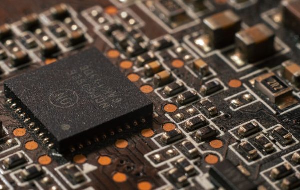 Primo piano di un chip su una scheda elettronica, simbolo della potenza di calcolo e dei costi dei modelli AI come Claude Opus 5.5