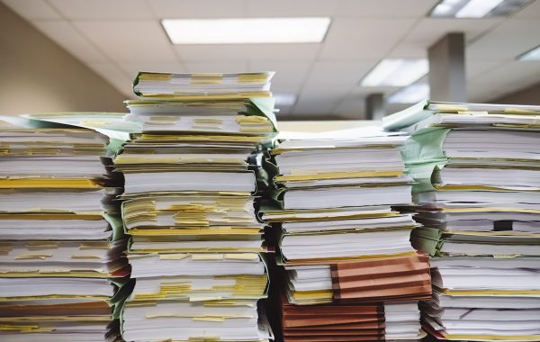 Pile di documenti cartacei e cartelle, il tipo di materiale che Cohere Parse 5 converte in dati strutturati