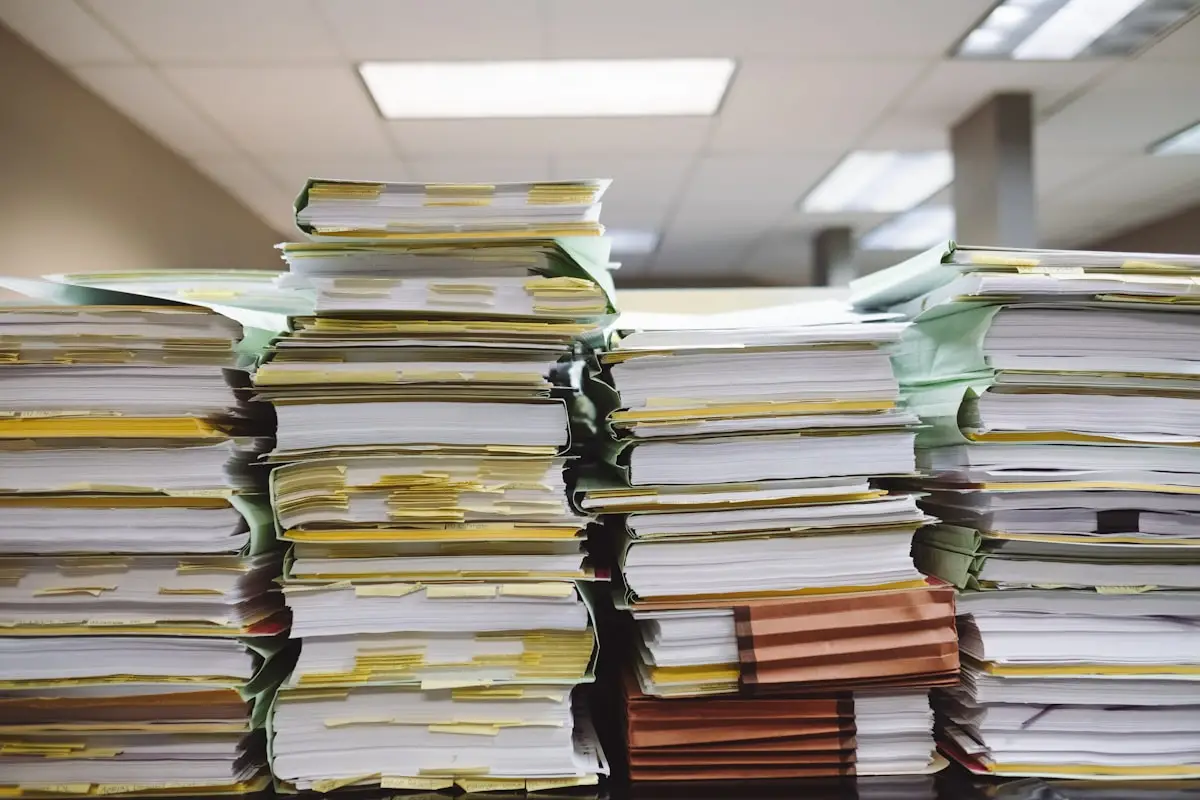 Pile di documenti cartacei e cartelle, il tipo di materiale che Cohere Parse 5 converte in dati strutturati