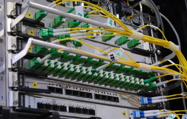 Cavi in fibra ottica collegati a uno switch di rete in un rack di data center per l'intelligenza artificiale