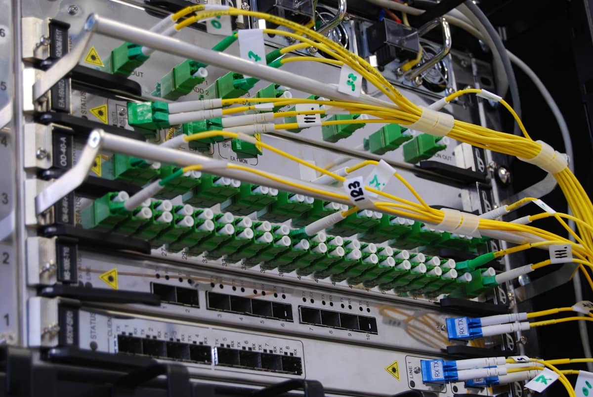 Cavi in fibra ottica collegati a uno switch di rete in un rack di data center per l'intelligenza artificiale