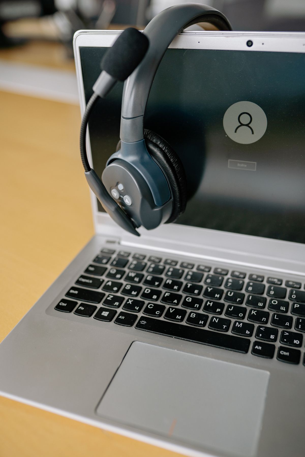 Cuffie con microfono appoggiate su un laptop, simbolo di assistenza clienti con agenti AI
