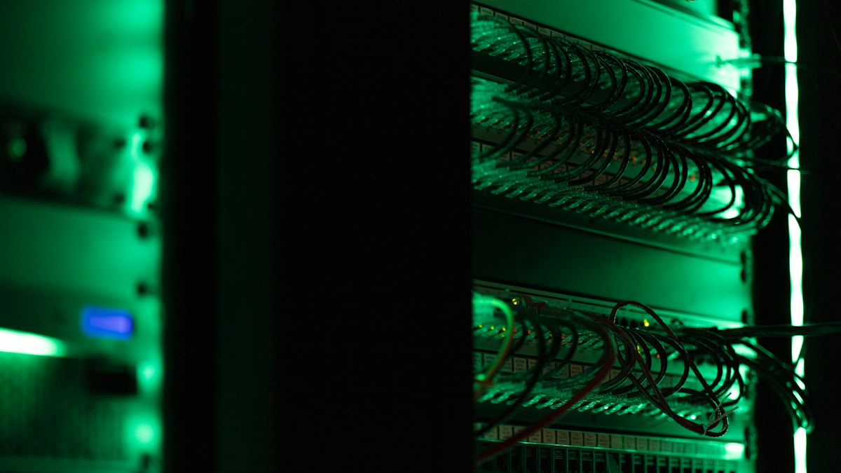 Rack di server con cavi di rete illuminati di verde in un data center