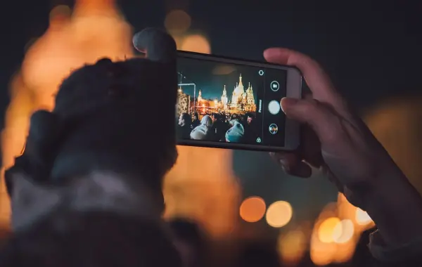 Persona che inquadra un edificio con la fotocamera dello smartphone, a illustrare Gemini Guided Vision su Android