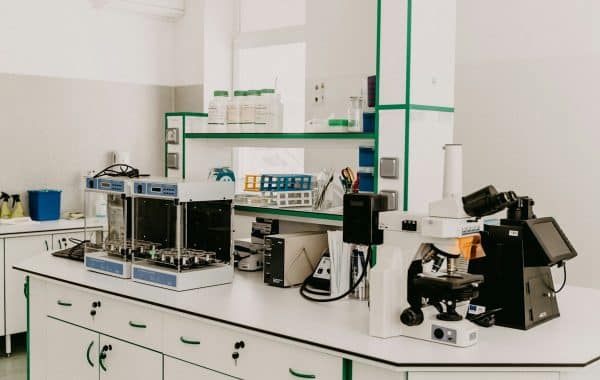 Laboratorio di ricerca farmaceutica con microscopio e apparecchiature analitiche