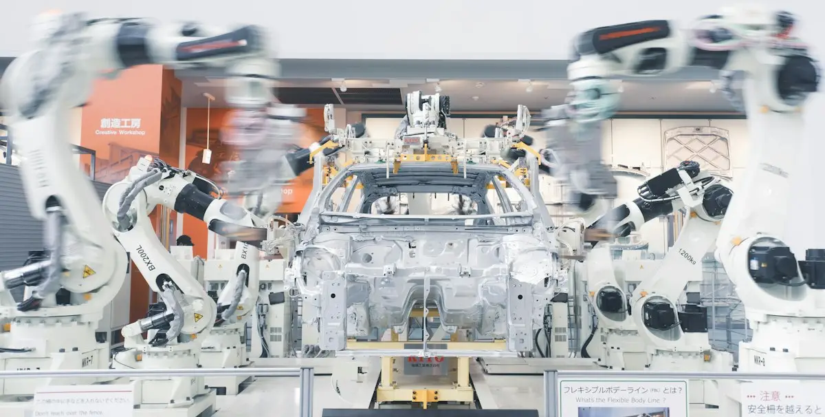 Bracci robotici che assemblano il telaio di un'auto su una linea di produzione industriale