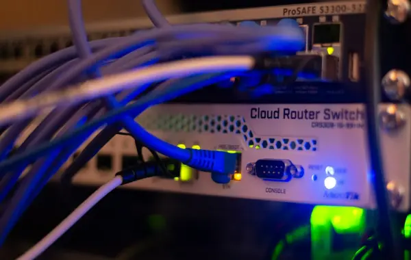 Primo piano di cavi di rete collegati a uno switch in un data center, simbolo della sicurezza degli agenti AI