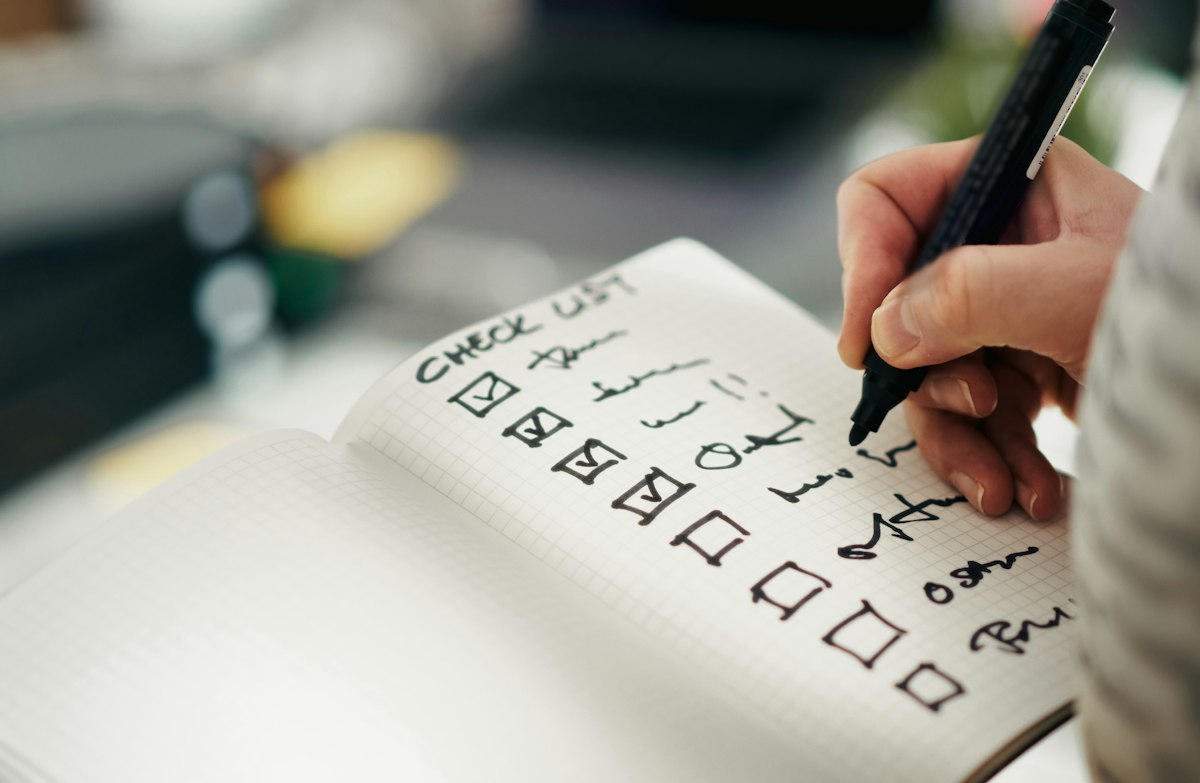 Una persona spunta le voci di una checklist di sicurezza su un foglio