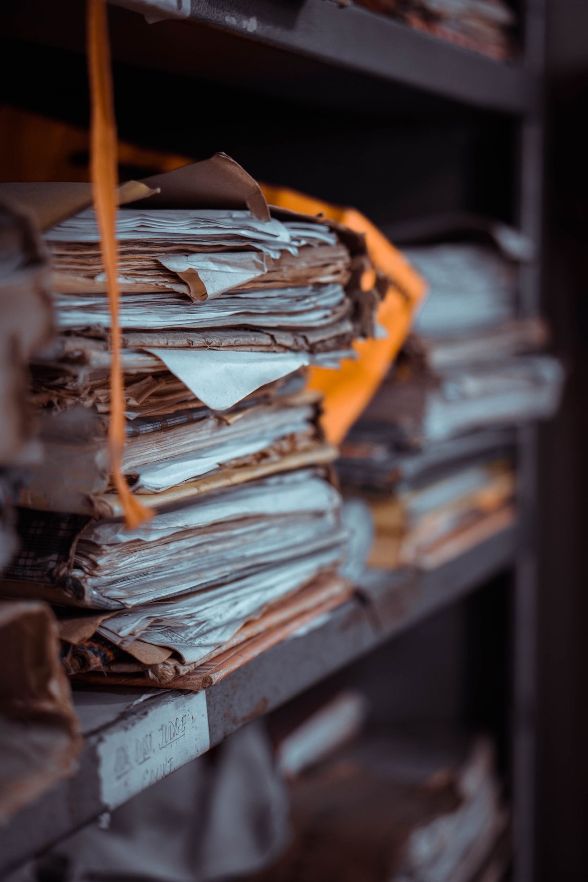 Pile di documenti e fascicoli cartacei accatastati su scaffali, immagine simbolo della digitalizzazione dei documenti con l'AI