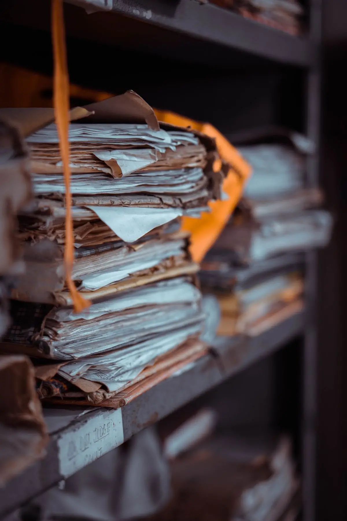Pile di documenti e fascicoli cartacei accatastati su scaffali, immagine simbolo della digitalizzazione dei documenti con l'AI