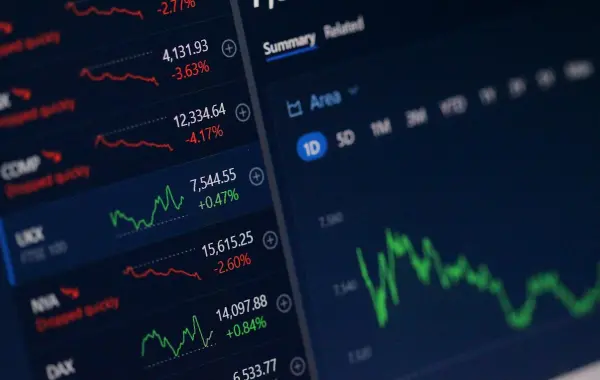 Schermi con grafici e quotazioni del mercato azionario, simbolo della finanza che alimenta gli investimenti nell'intelligenza artificiale
