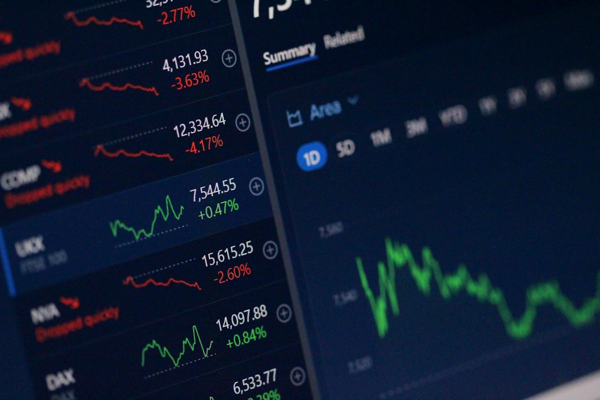 Schermi con grafici e quotazioni del mercato azionario, simbolo della finanza che alimenta gli investimenti nell'intelligenza artificiale