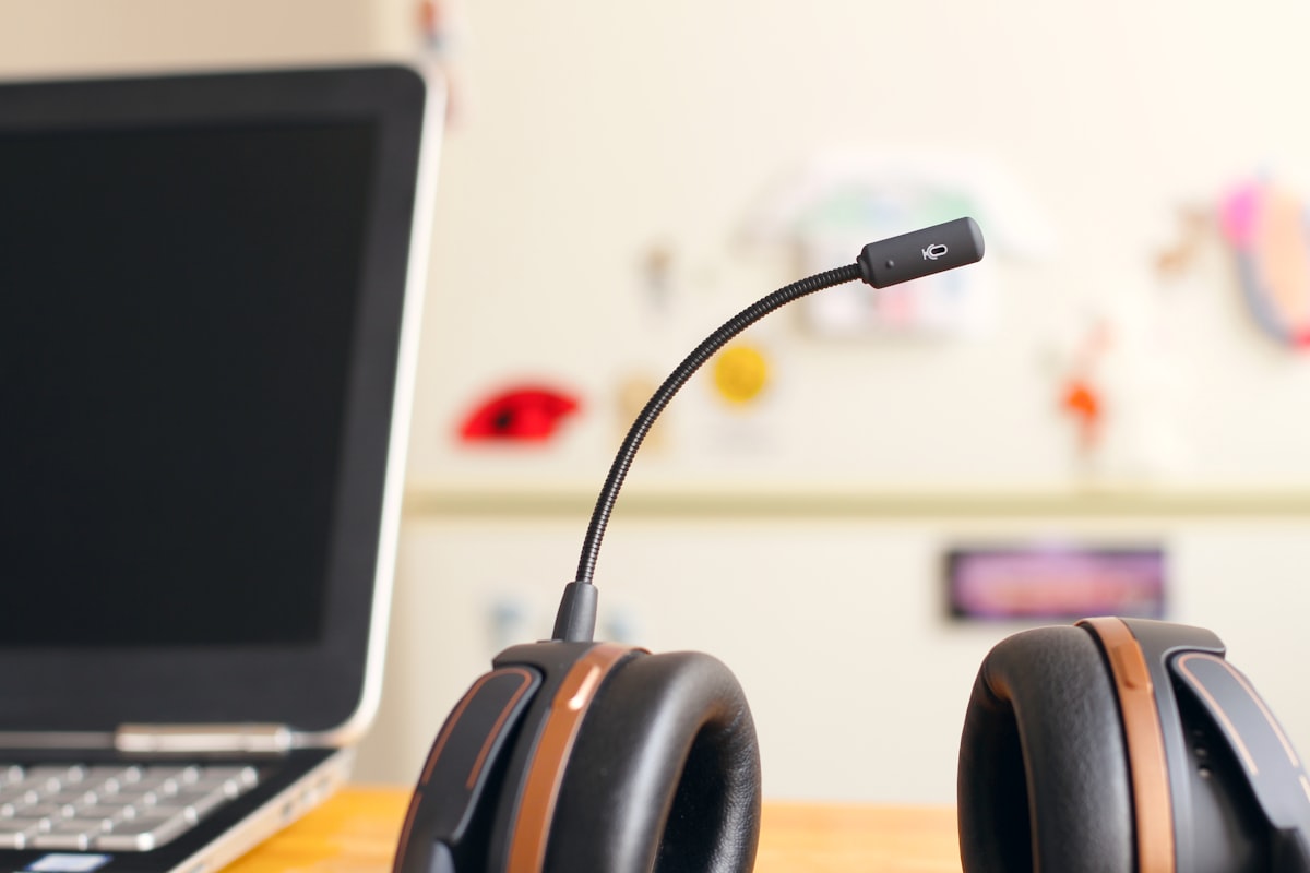 Cuffia con microfono accanto a un computer portatile: AI conversazionale e vocale per il servizio clienti