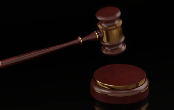 Martelletto da giudice in legno su un tavolo, simbolo di legge e responsabilità