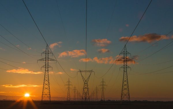 Tralicci e linee elettriche ad alta tensione al tramonto, simbolo delle infrastrutture critiche