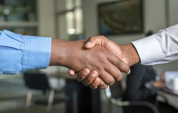 Stretta di mano tra due persone in un contesto di accordo professionale